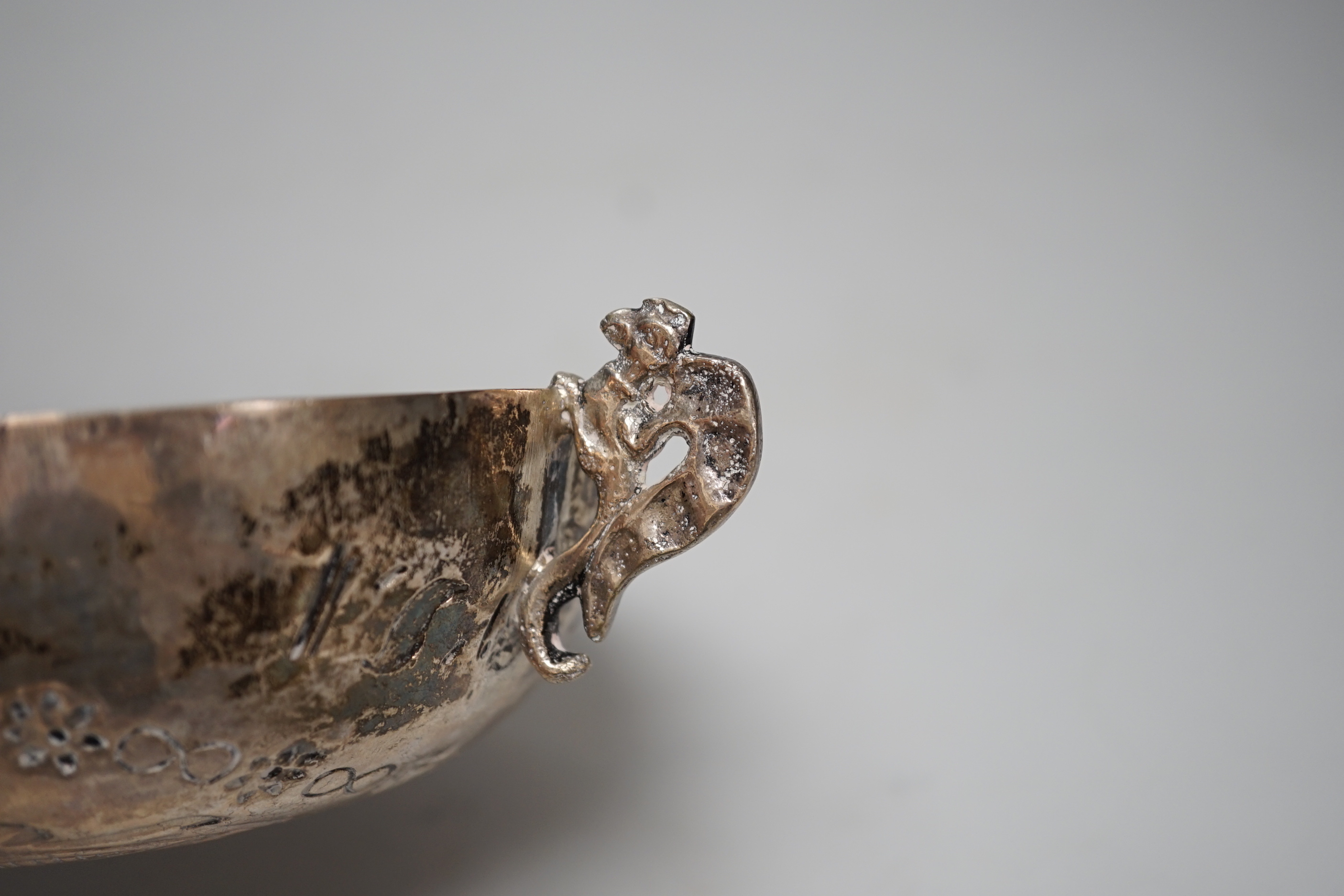 An antique continental white metal twin handled dish, embossed with a crest and double headed eagle, 19.3cm wide overall